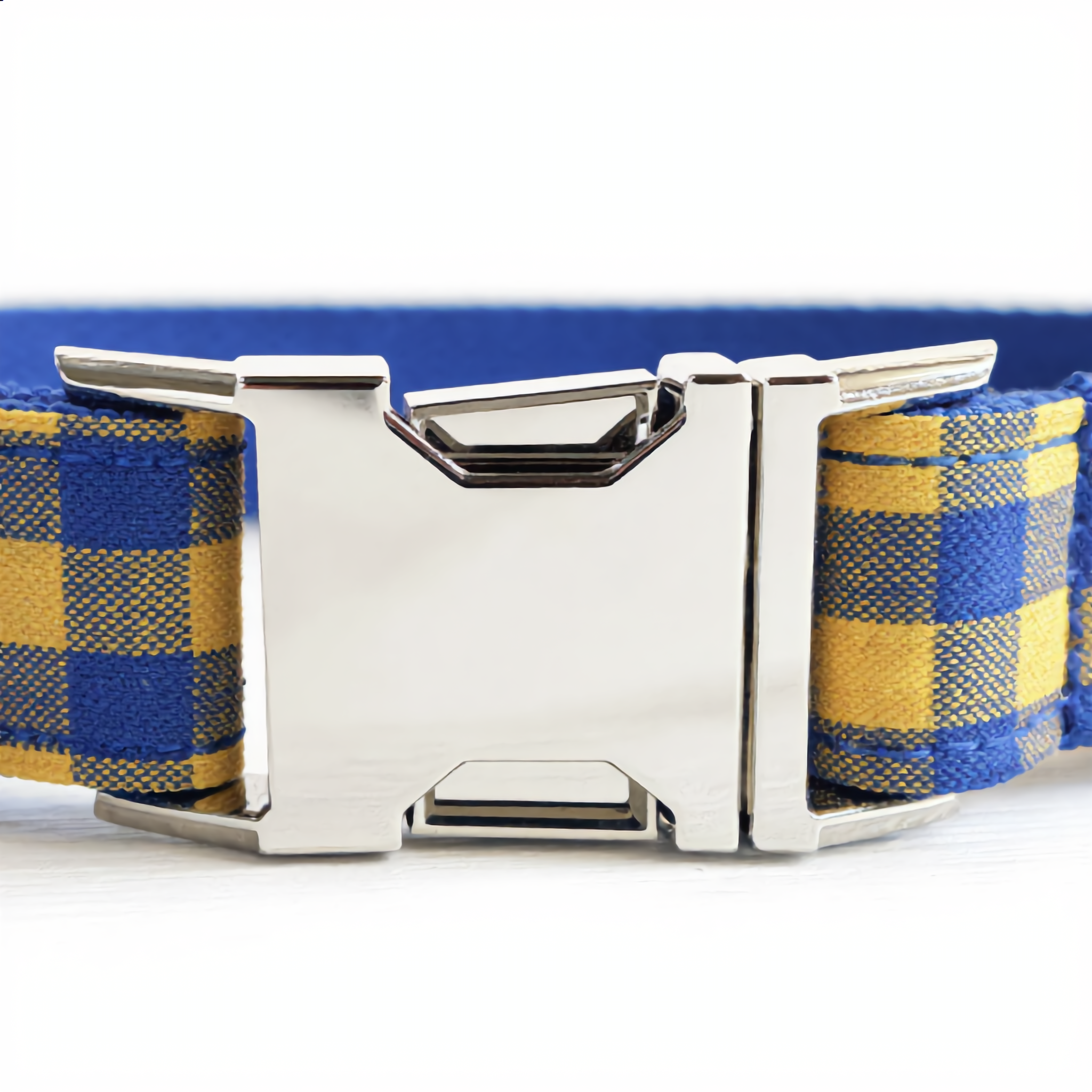Dog collar with blue and yellow plaid pattern and silver buckle on a white background